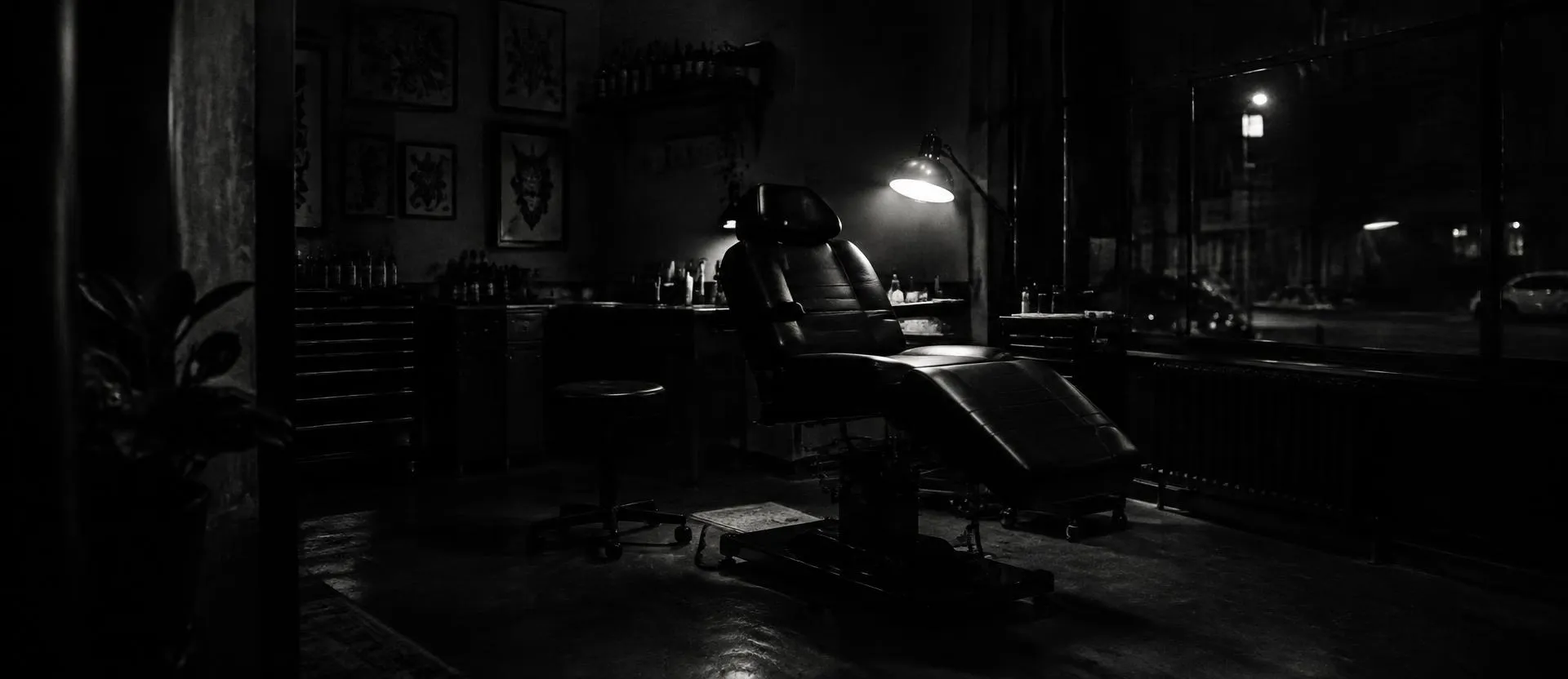 Tattoo studio at night with a lamp over an empty chair