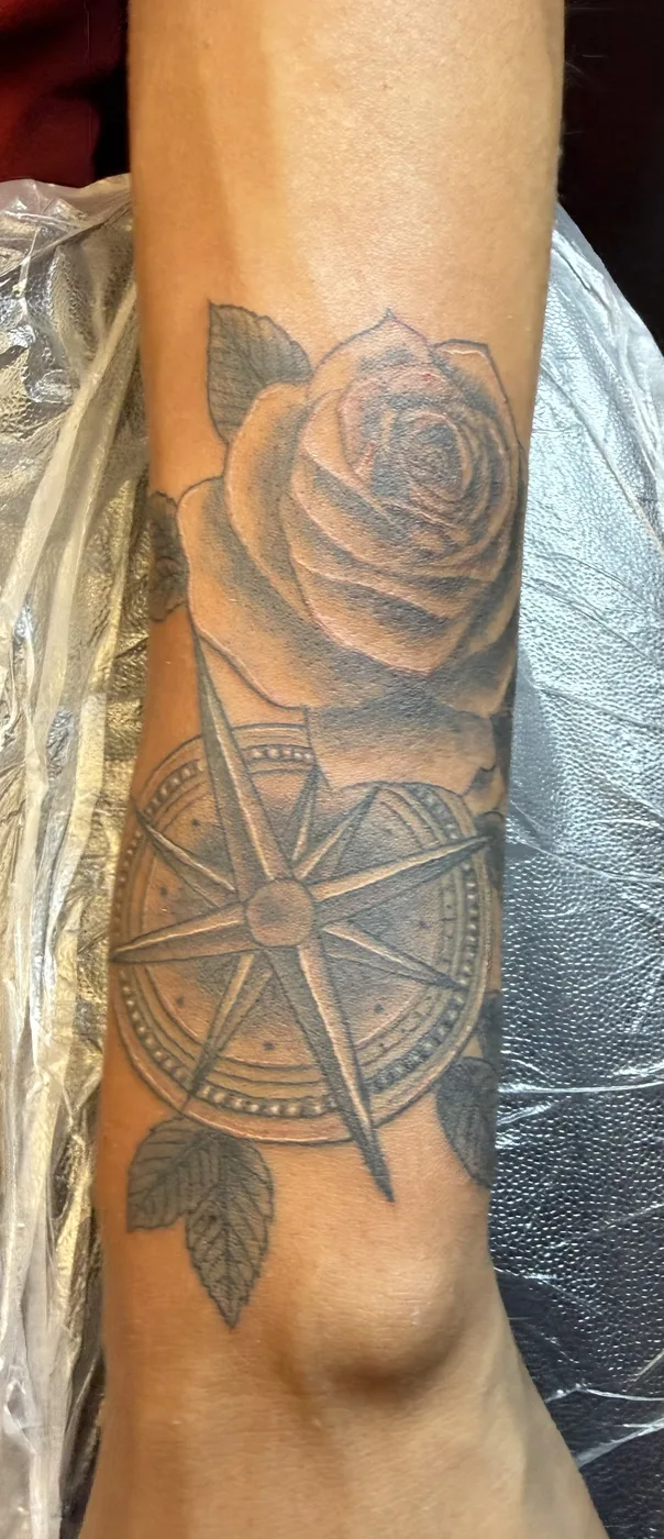 Black and gray rose and compass forearm tattoo